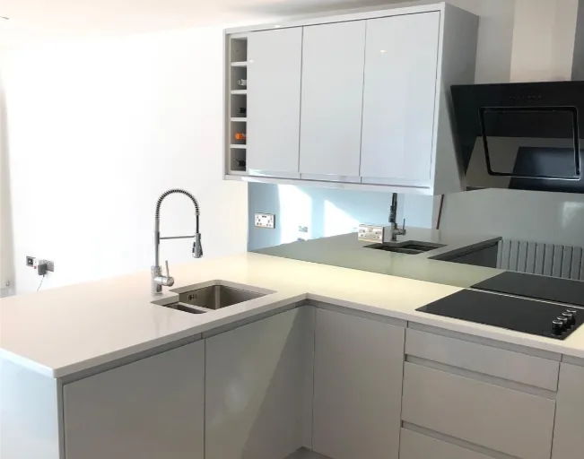 Modern gloss handless kitchen with hose tap, induction hob & wine rack